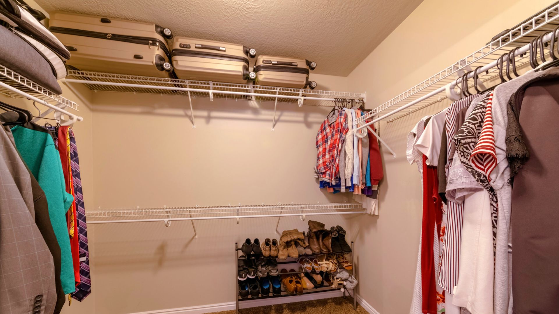 A spacious walk-in closet with white wire shelving installed on three walls, maximizing vertical storage.