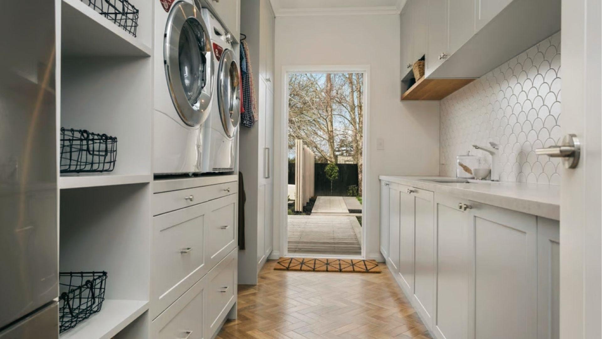 Open laundry nook with a stacked washer and cabinets replace bifold doors for easy access.