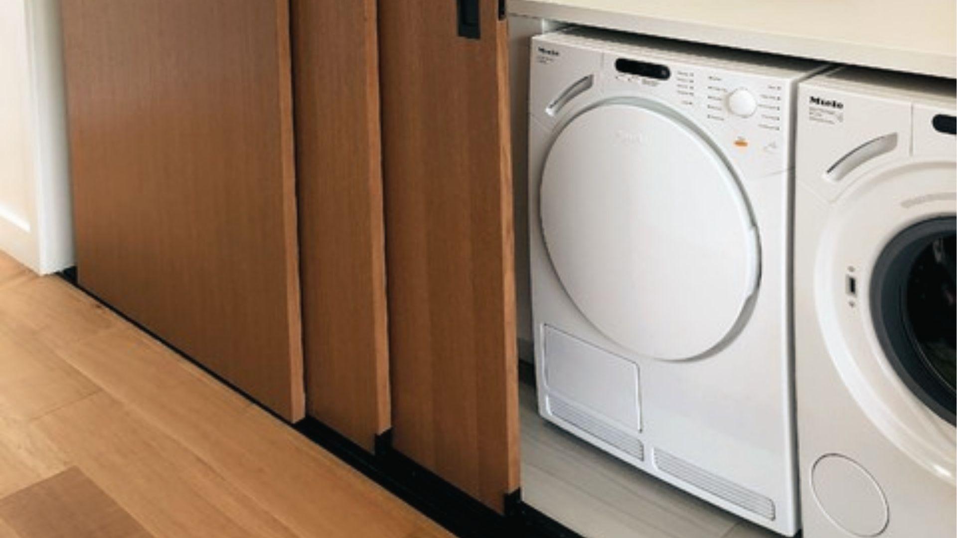 Sliding wood panel doors hide washer dryers under the counter as sleek bifold door swaps.