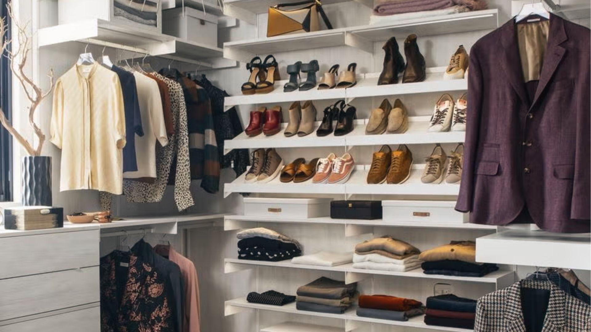 Corner walk-in closet conversion with floating shelves, angled shoe displays, folded clothes, and blazers.