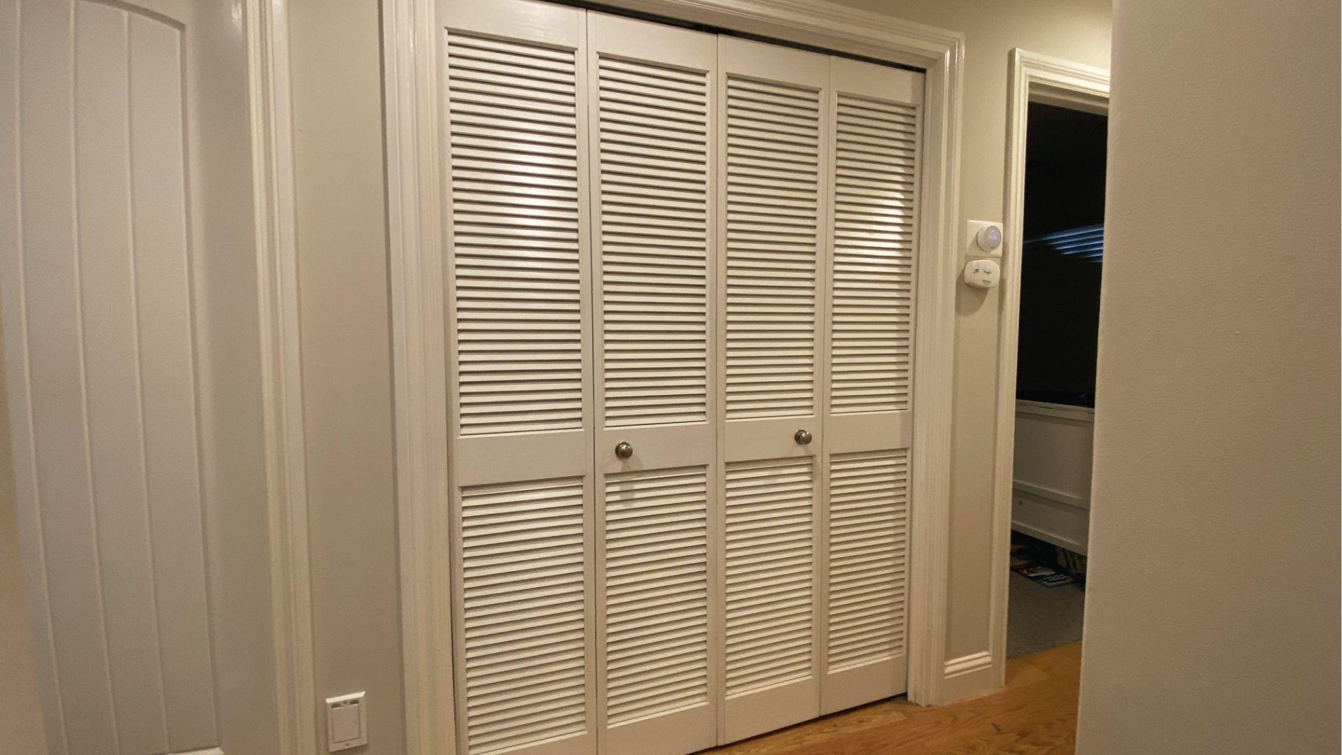 White louvered doors replace bifolds for laundry closet ventilation and classic look.