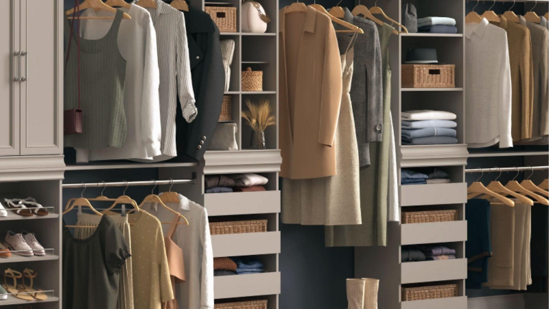 Spacious gray walk-in closet with hanging rods, shelves, wicker baskets, and pull-out drawers.