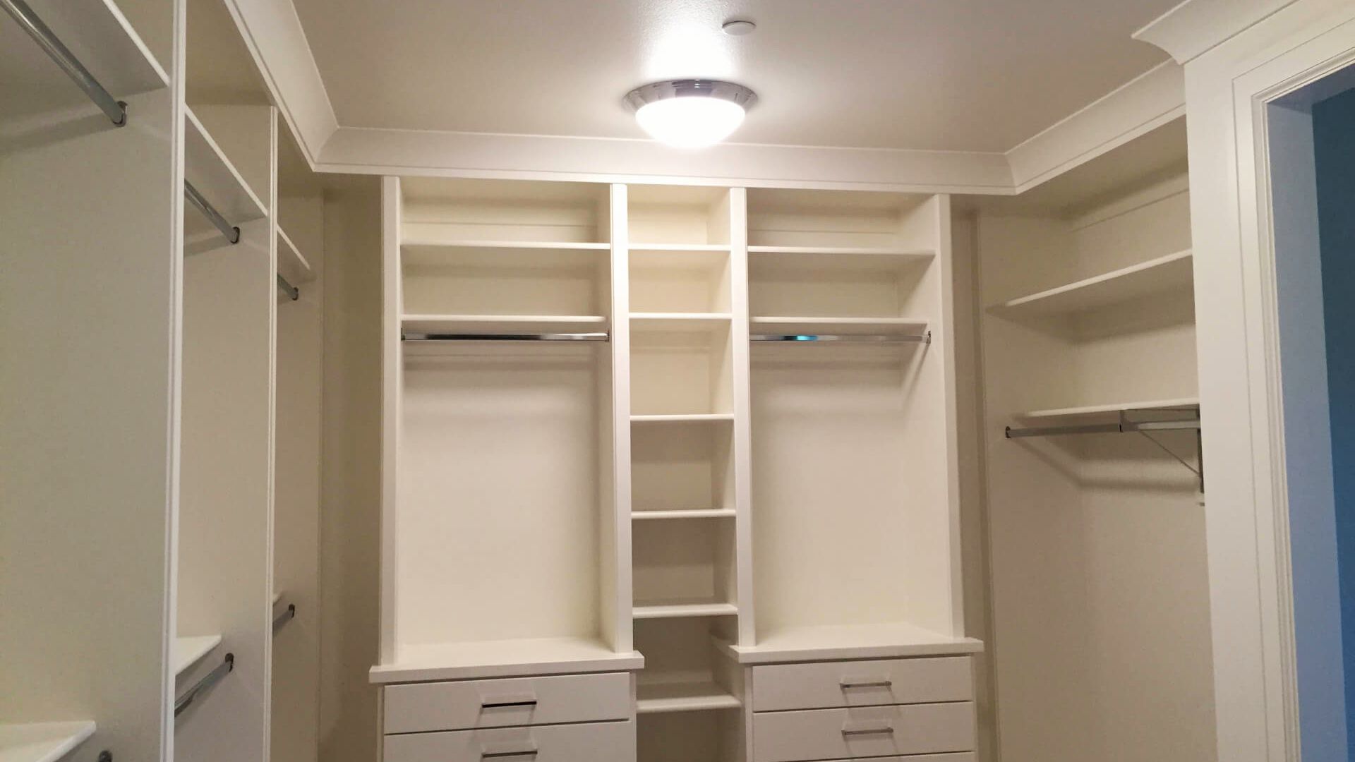 Empty white custom closet showing multiple rod mounting positions for flexible height options.