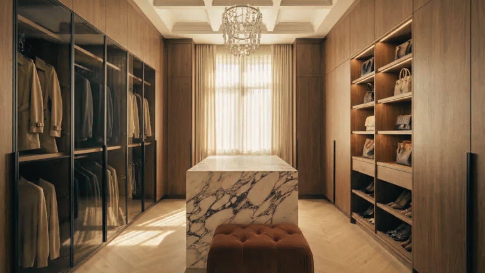 Luxury walk-in closet with 14-inch deep lit shelves for handbags above and 24-inch deep hanging sections.