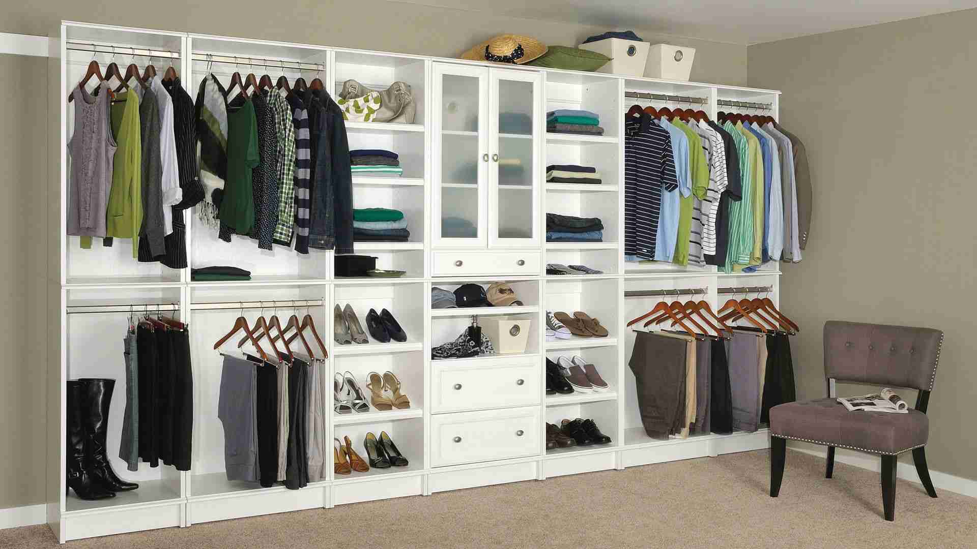 White modular closet system with open shelving, hanging rods, and frosted glass cabinets.
