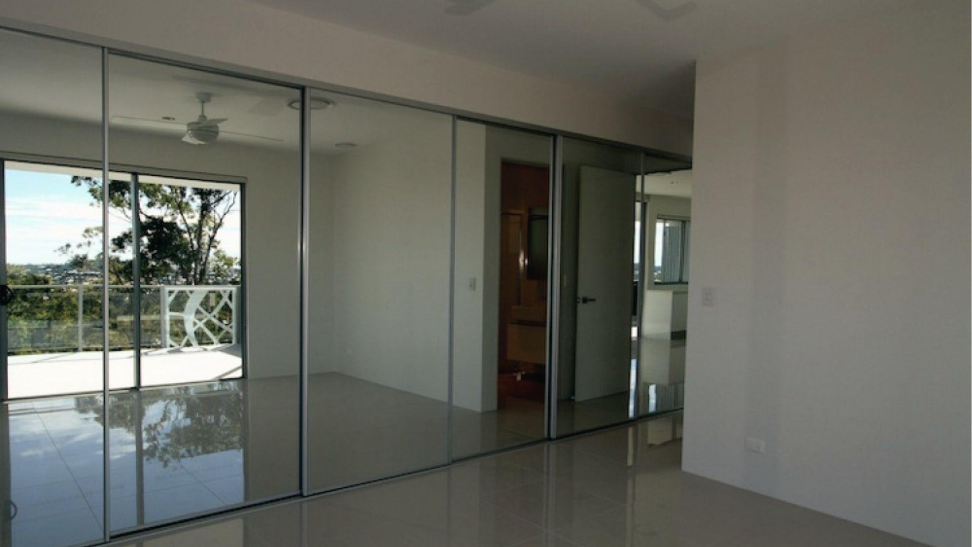 Mirrored sliding doors replace bifold doors, adding light and space to laundry area.