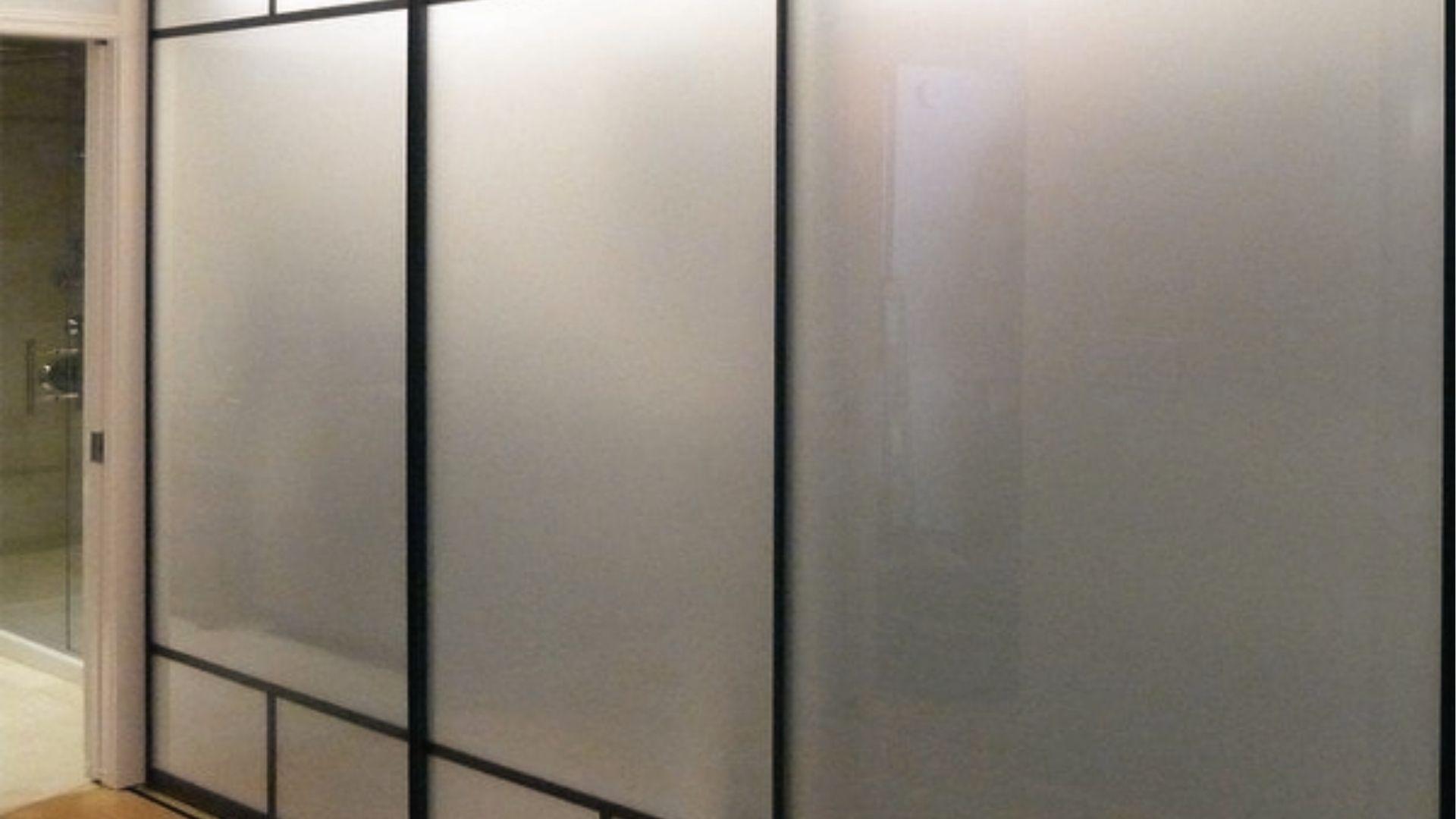 Frosted glass sliding panels with black frame hide laundry, stylish bifold door swap.