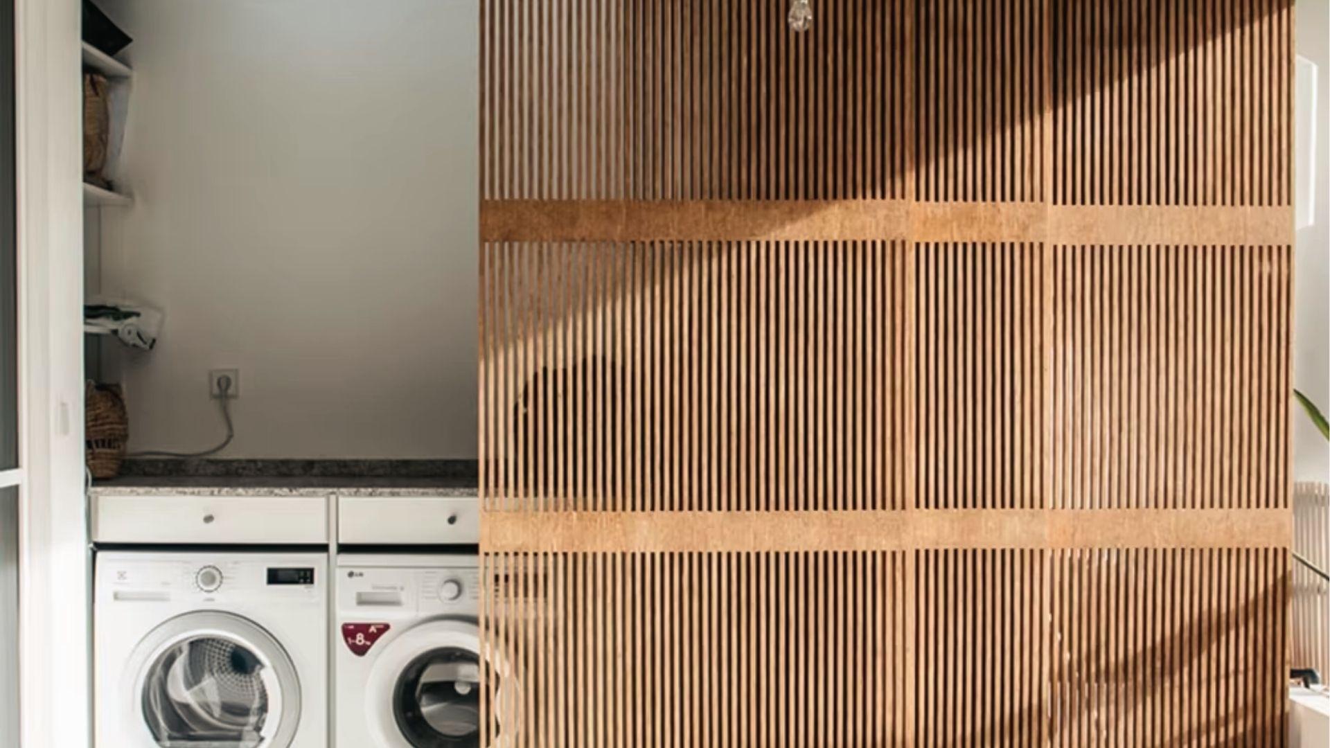 Slatted wood sliding panel screens laundry area, warm bifold door alternative.