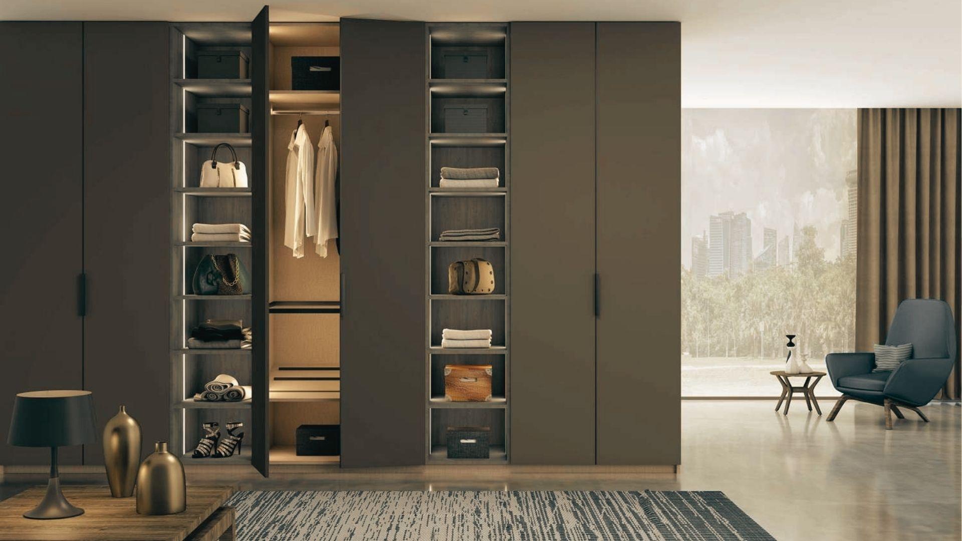 Matte taupe floor-to-ceiling wardrobe with hinged doors and LED-lit open shelving in a luxury bedroom.