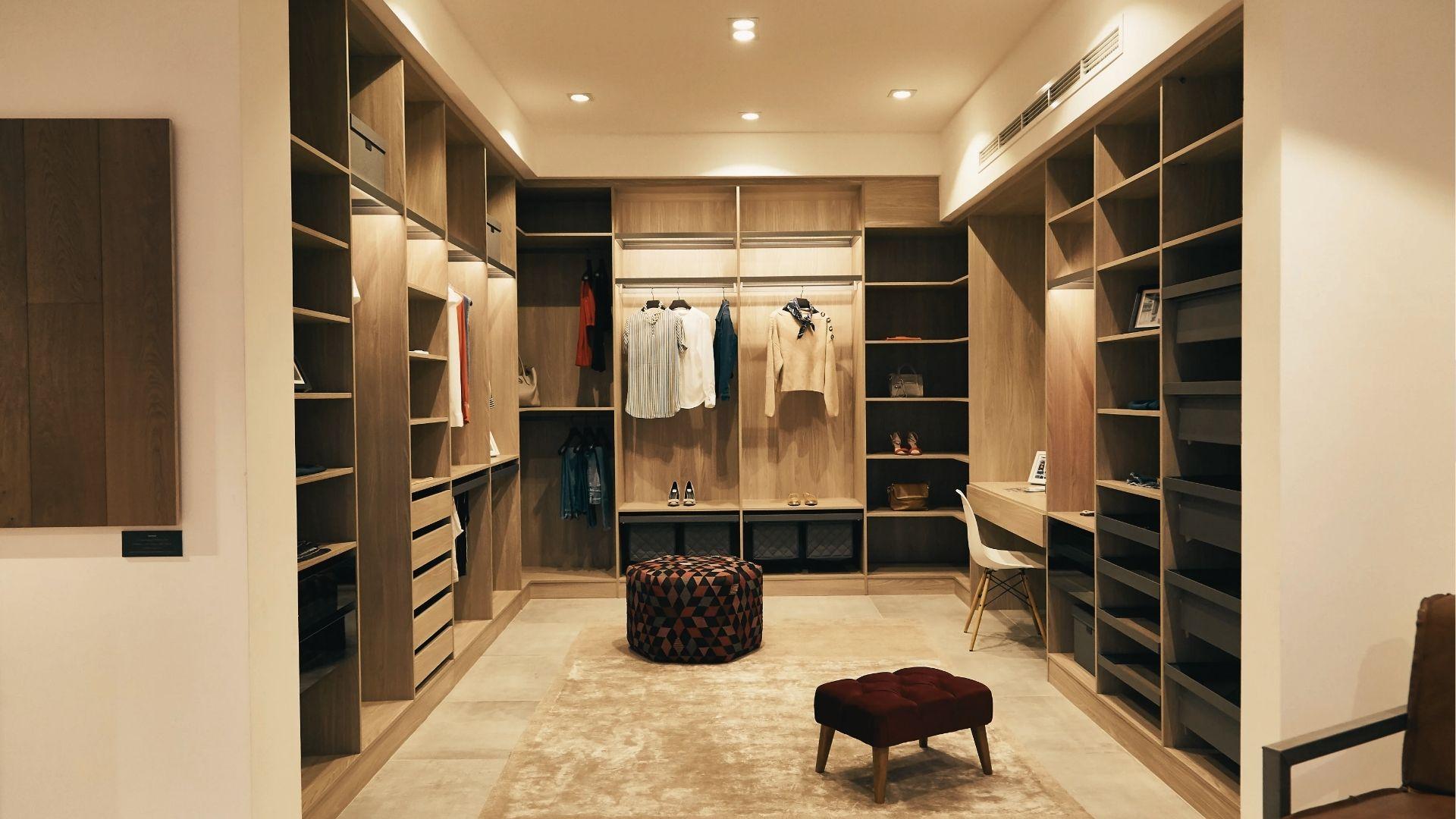 Large walk-in closet with tall vertical shelving and multiple hanging rod heights for shirts, pants, and long garments.