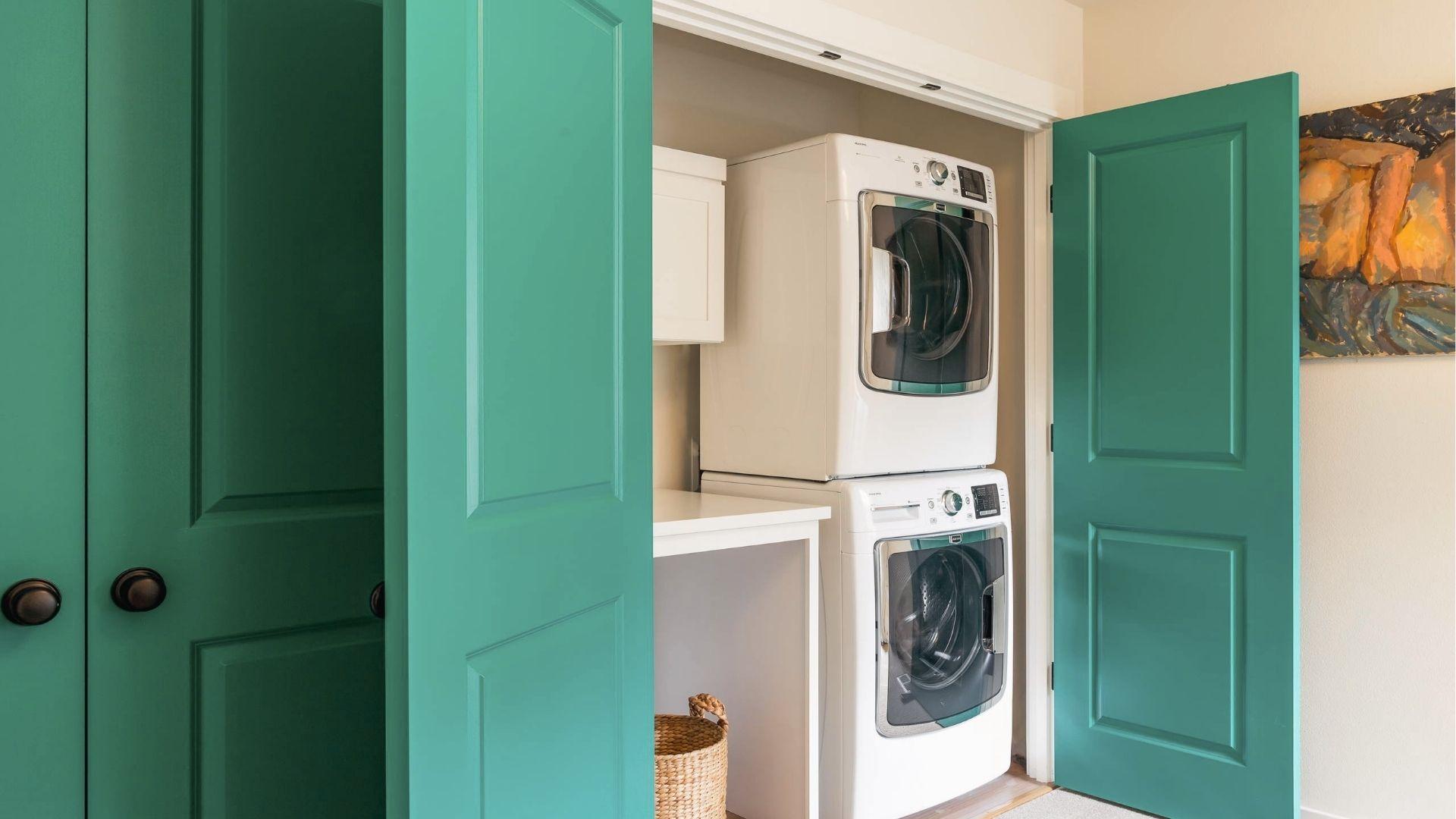 Bold teal French doors replace bifold doors for statement laundry closet entry.